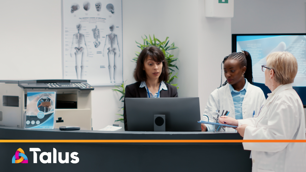 Three healthcare professionals collaborating at a clinic front desk, illustrating the value of a reliable freelancer bench for HealthComms agencies.