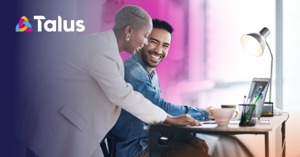 Two professionals collaborating at a desk reviewing resourcing options on a laptop, representing the process of building a business case for leadership approval